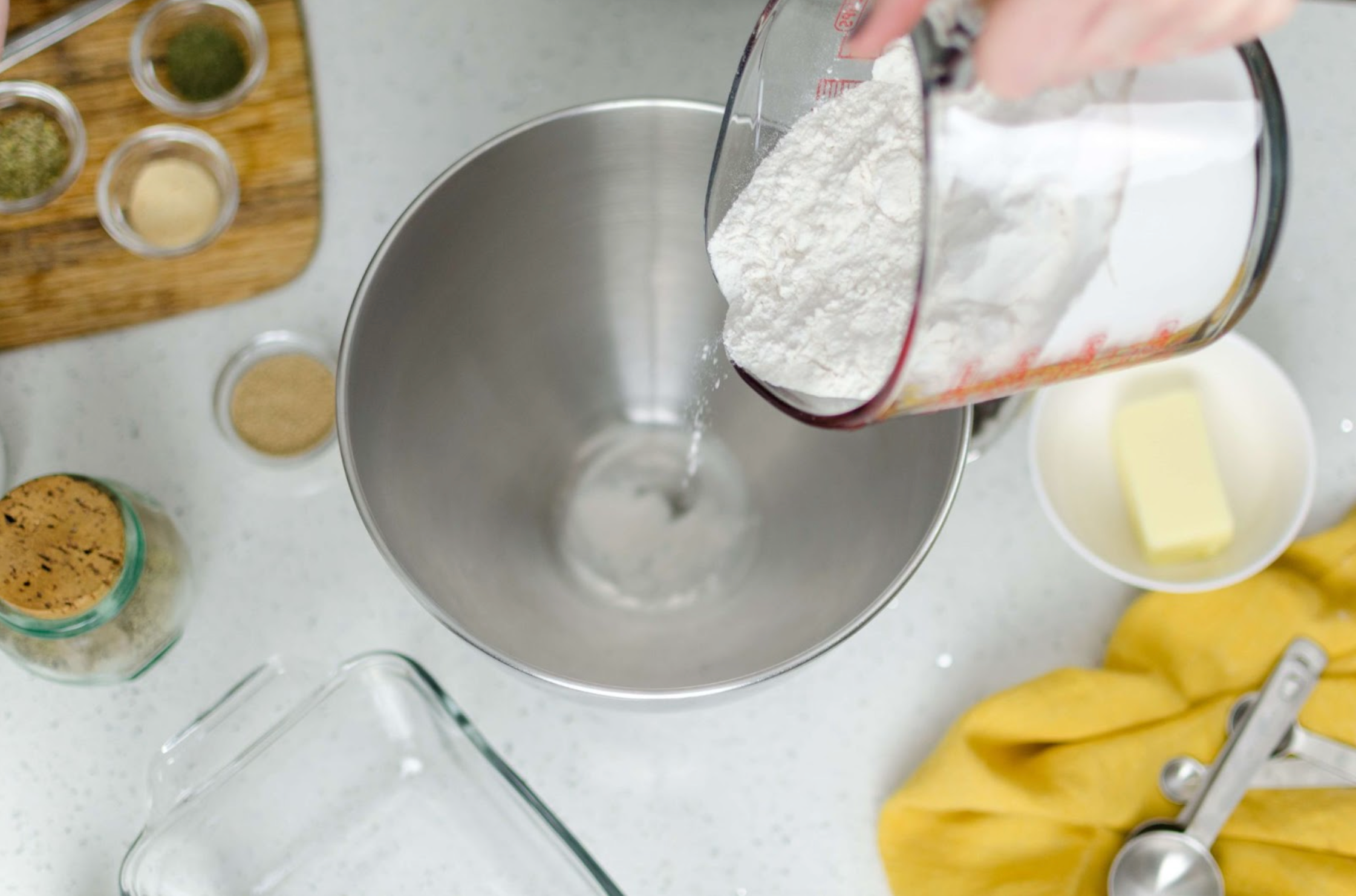 baking ingredients on the counter with scotty's everyday baking mix being poured in a bowl